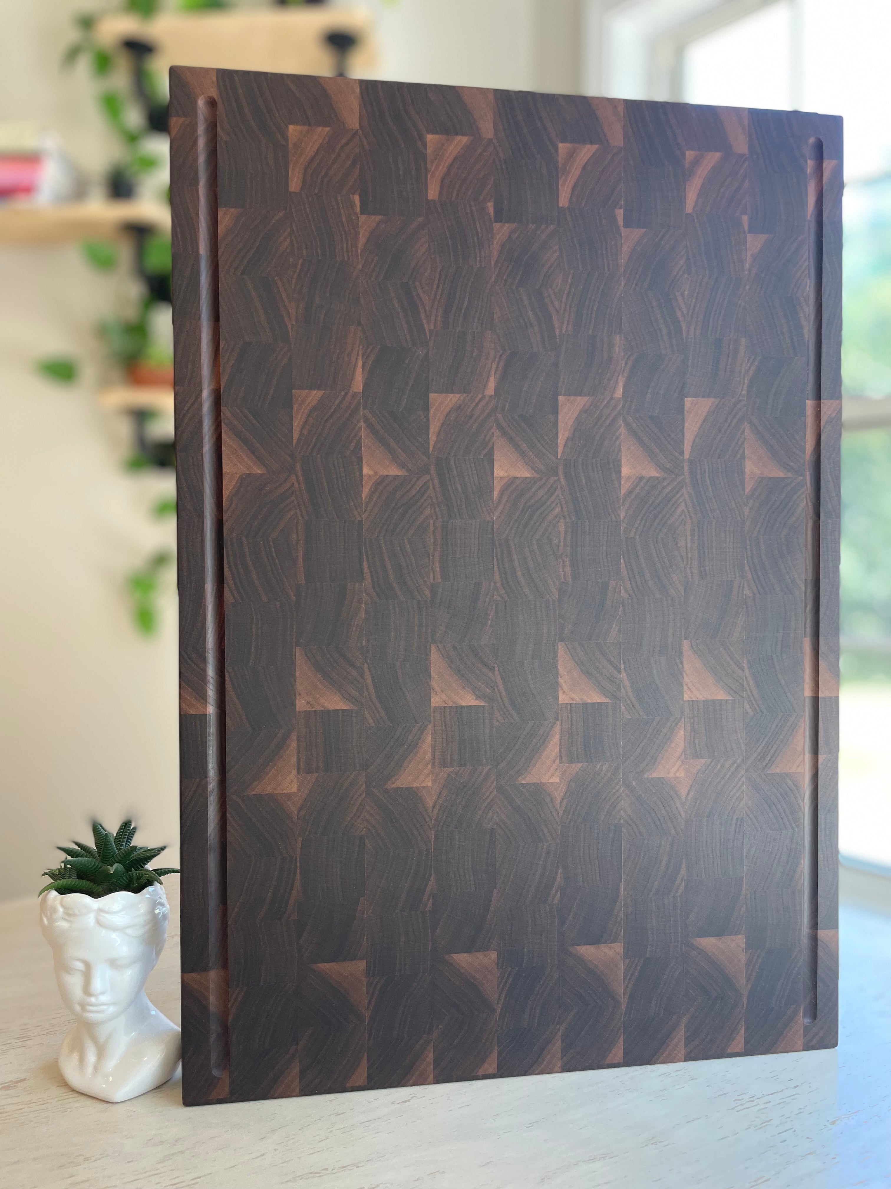 Large walnut end grain cutting board with geometric grain pattern, handcrafted by Thess Boar 