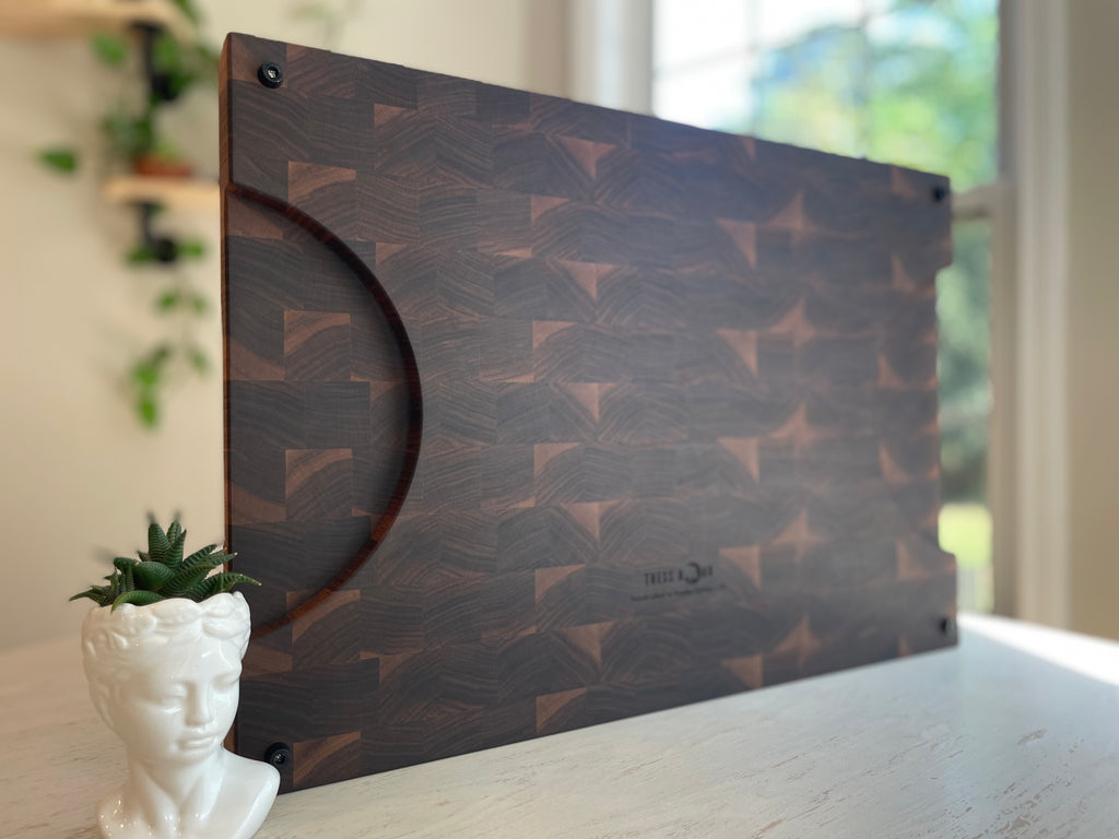 Large handcrafted walnut end grain cuttin board with distinctive geometric grain pattern and routed handle