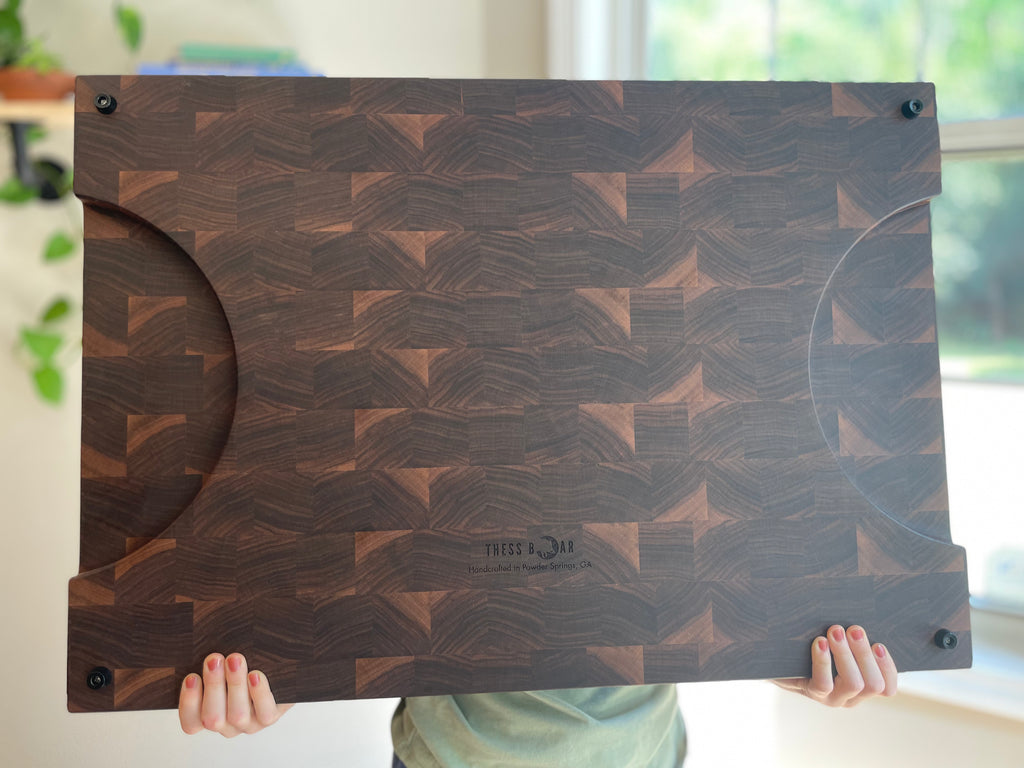 Large handcrafted walnut end grain cutting board size reference held  by human