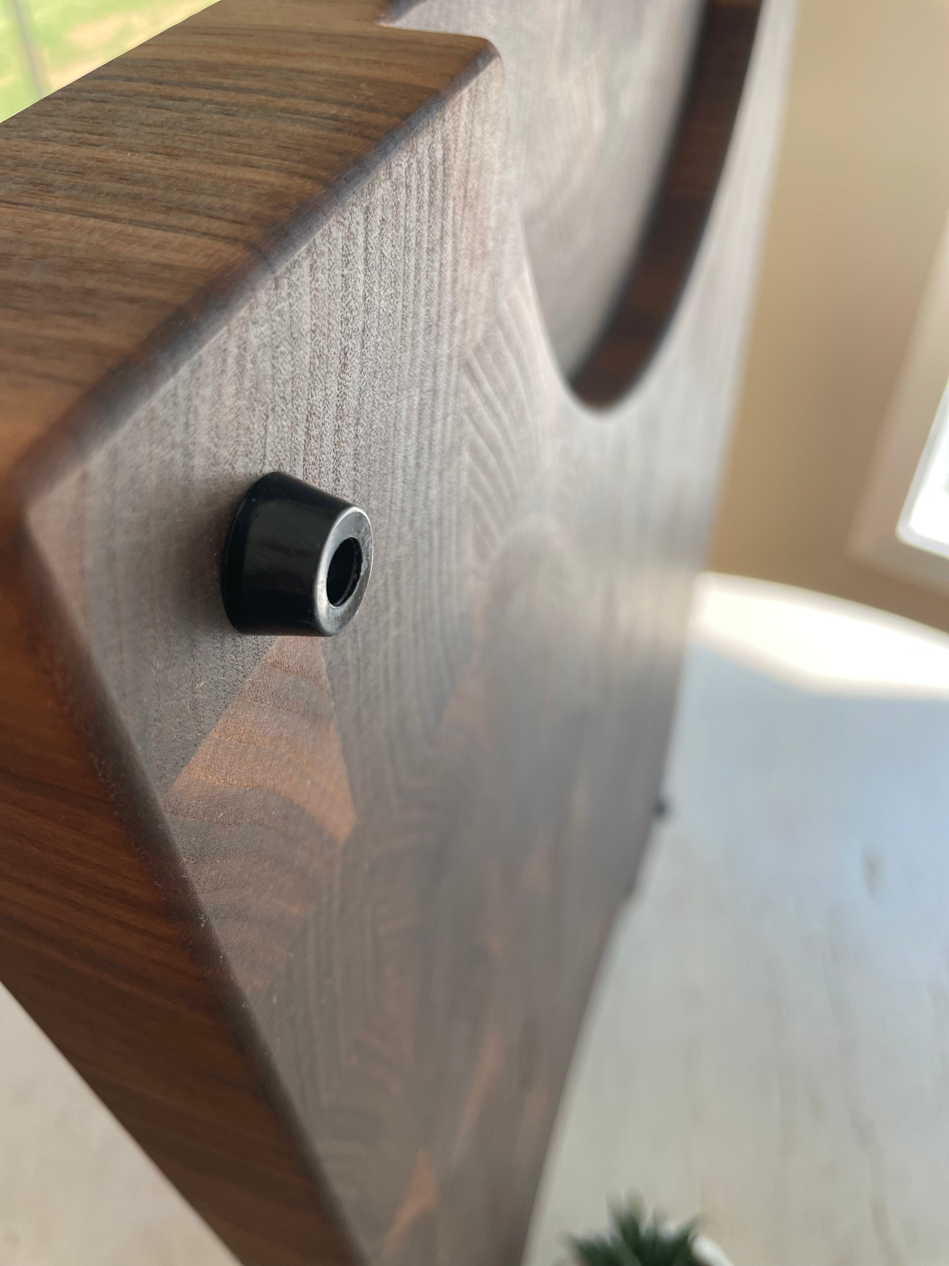 Close-up of a handcrafted walnut end grain cutting board showing routed handle and thick construction. 